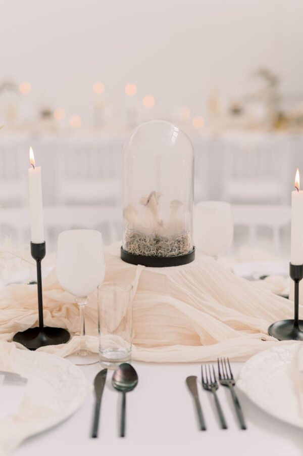 A formal table adorned with crisp white linen and elegant black and white tableware.