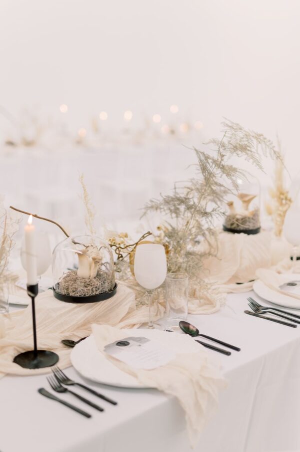 A formal table adorned with crisp white linen and elegant black and white tableware.