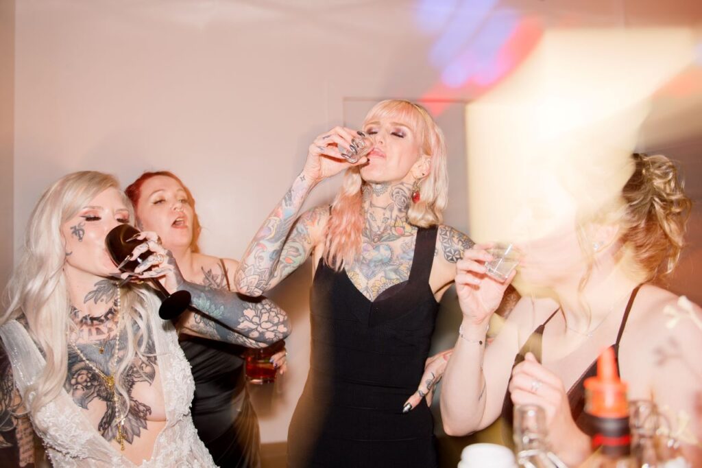 A gathering of tattooed women savoring refreshments at a lively party