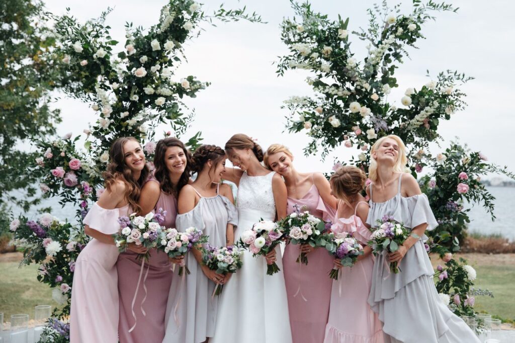 Bride and her bridal party ouside wearing mix matched bridesmaid dresses