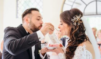 bride and groom eat wedding cake off one plate at reception