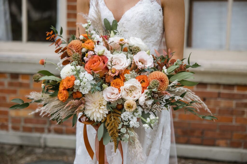 bride holding a large wedding bouquet with beautiful earth tones