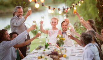 best man speech outside with everyone raising glasses to toast newlyweds