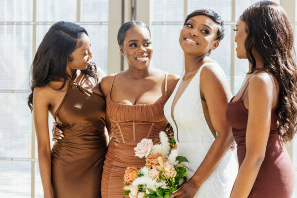 Group of bridesmaids posing in matching brown dresses