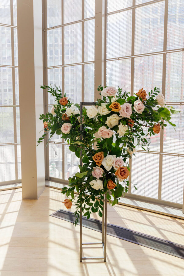 Colorful flowers arranged in tall vases, elegantly placed on the floor of a room.