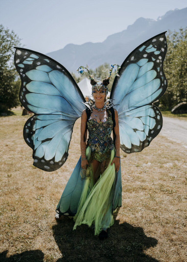 A woman adorned as a vibrant blue butterfly, gracefully displaying her wings in a captivating fashion.
