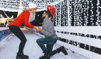 Handsome man proposing a beautiful woman to marry him in ice skating rink