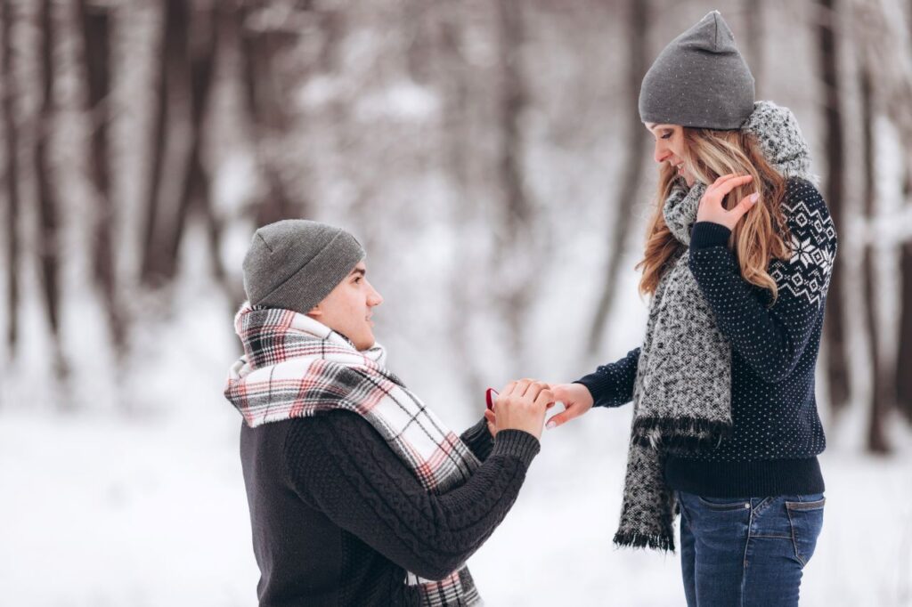man on one knee in the snow proposing to girlfriend