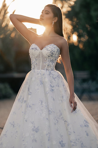 Stunning golden hour image of bride wearing blue floral print strapless wedding dress trends