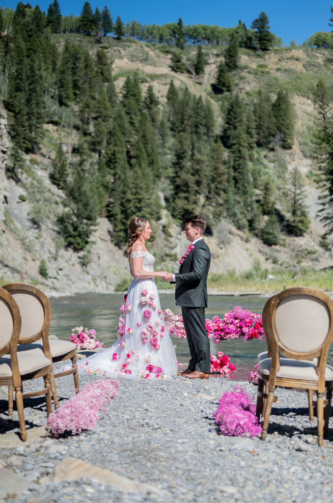 Bride and groom at riverside ceremony during Barbie-styled wedding shoot at The Crossing at Ghost River