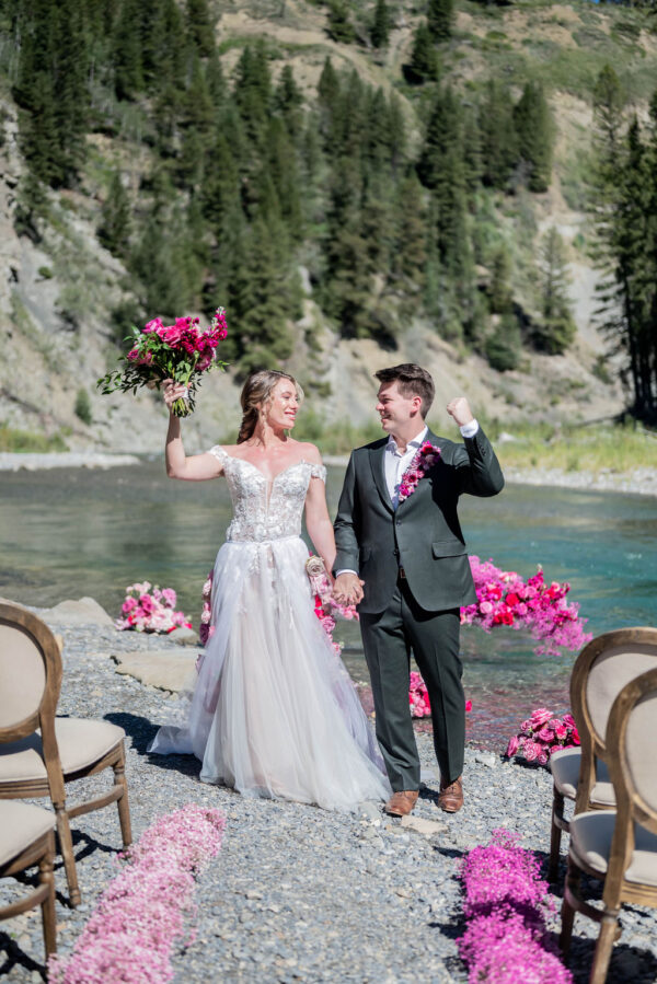 Bride and groom celebrate after riverside Barbie-styled wedding shoot with beautiful pink flowers