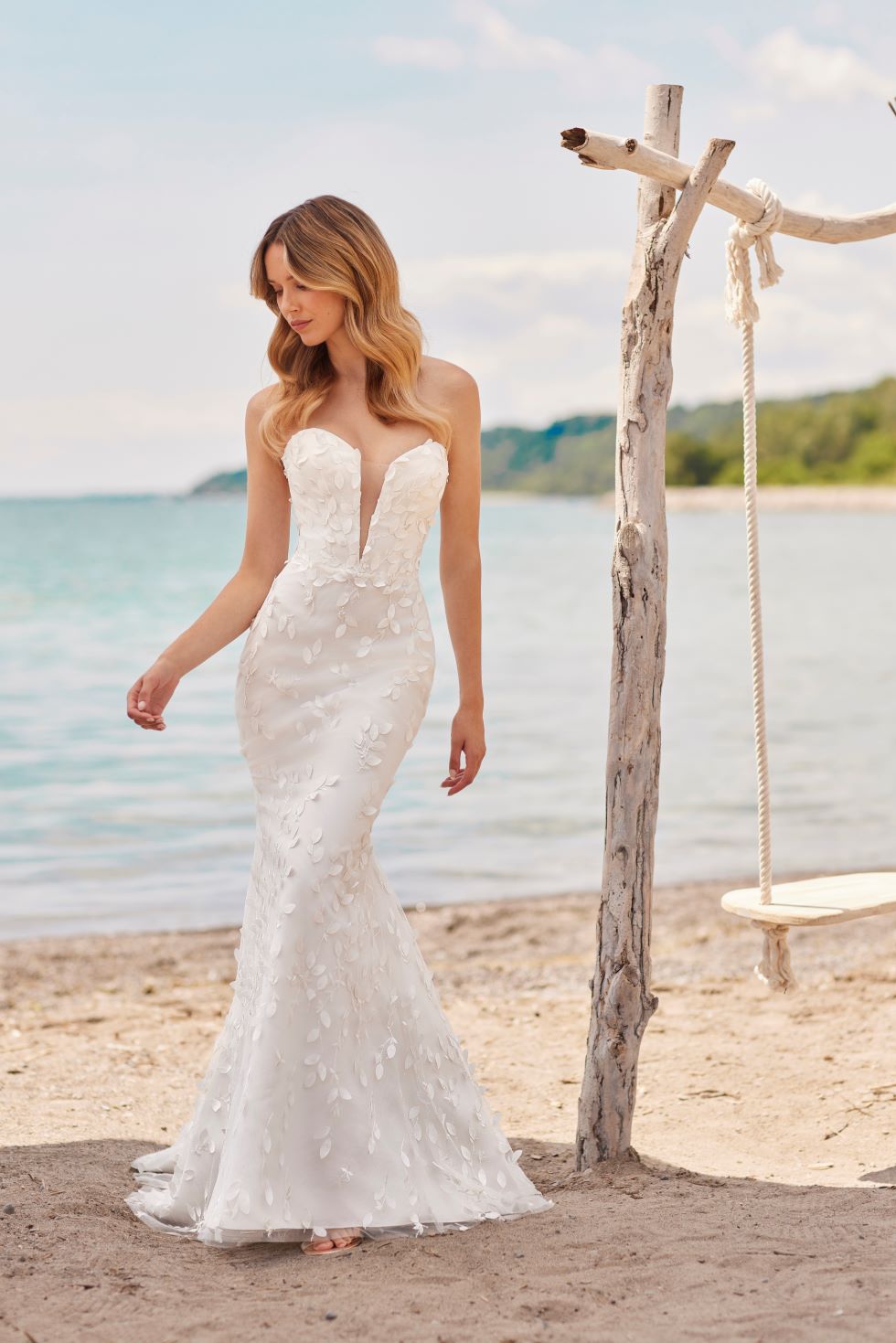 Beautiful bride wearing strapless lace wedding dress on beach