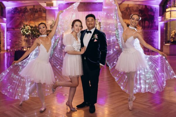 bride and groom pose with ballerinas at wedding reception