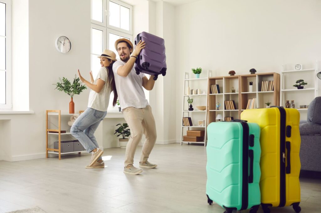 couple dancing in living room while packing for Cancun honeymoon