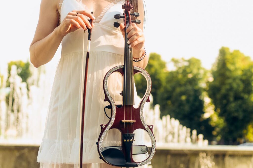 woman standing holding an electric violin a trending innovative wedding ideas wedding entertainment