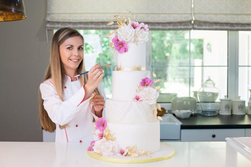 wedding cake vendor decorating tiered wedding cake 
