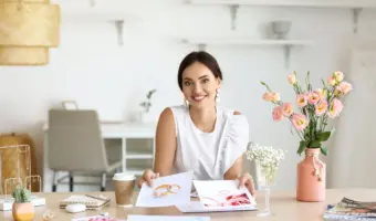 pretty wedding planner sits at desk showing hidden wedding costs to couple