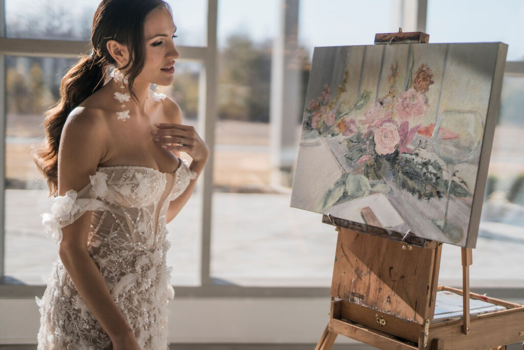 bride looking at wedding painting done by live painter