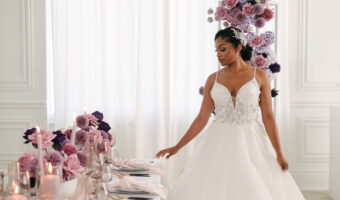 beautiful bride in strapless gown poses for portrai next to stunning tablescape wtih lavender decor at styled shoot