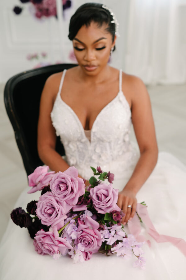 gorgeous bride sitting in ivory wedding dress at styled shoot