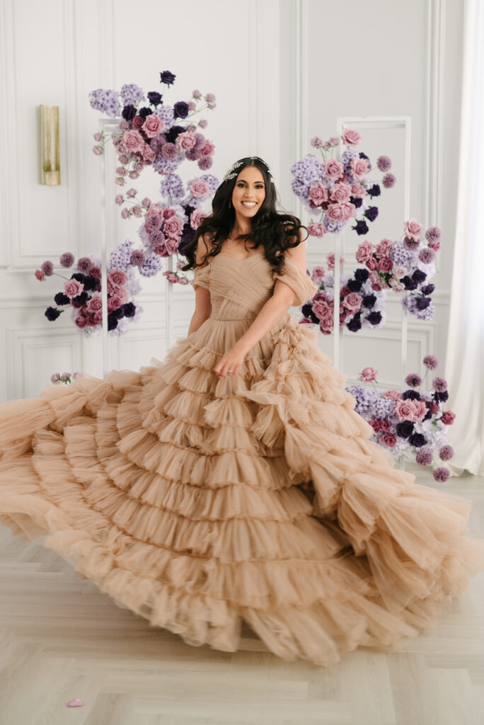 bride twirling in dark champagne wedding dress with ruffled skirt during styled shoot