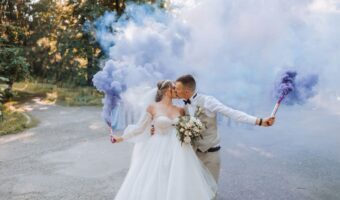wedding sparkler exit alternatives bride and groom hold purple smoke bombs