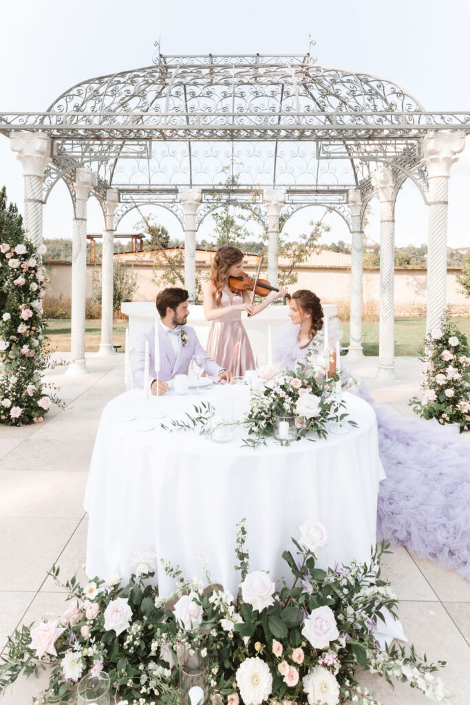 romantic sweetheart table for bride and groom with violinist playing at the Domaine des Séquoias