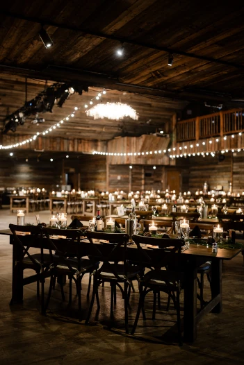 A charming rustic wedding reception adorned with glowing string lights, creating a warm and inviting atmosphere for guests