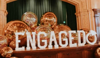 illuminated engaged sign with large metallic balls behind as engagement celebration decor