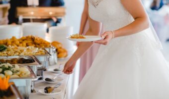 bride getting food from wedding caterer buffet table