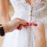 wedding dress mishaps woman fixes buttons on back of dress