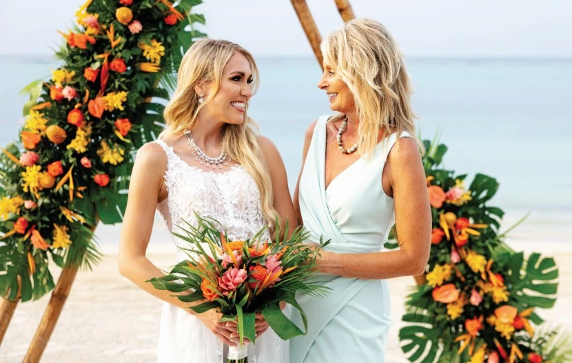 Mother and bride standing side by side on a beach