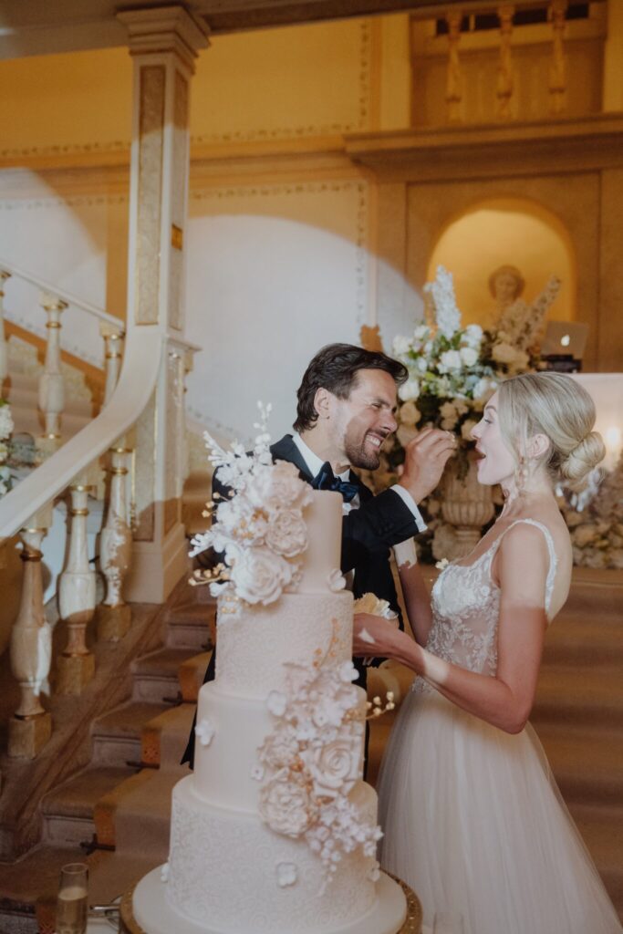 bride and groom at cake cutting during luxury palace wedding