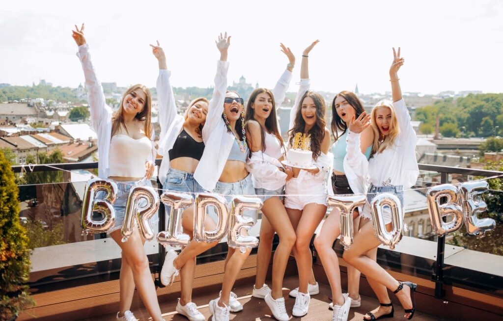 group of happy girls celebrate bachelorette party on rooftop