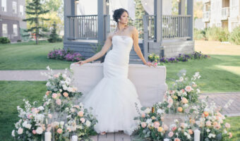 bride posing for portrait by couch with spring wedidng flowers and gazebo in the background