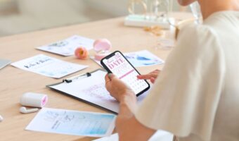 woman at table using phone to send save the dates wedding planning secrets