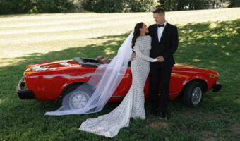 Bride and groom pose next to red convertible sports car at ourdoor wedding at Mt. Lehman Winery