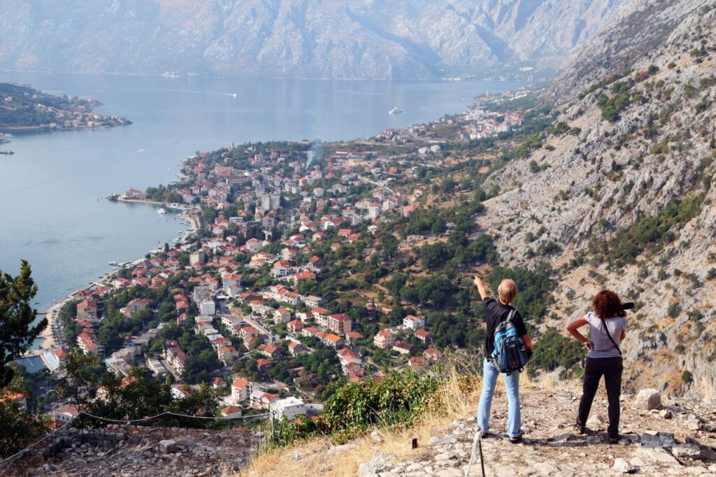 couple overlooking Kotor lake in Montenegro a non-traditional honeymoon destinations