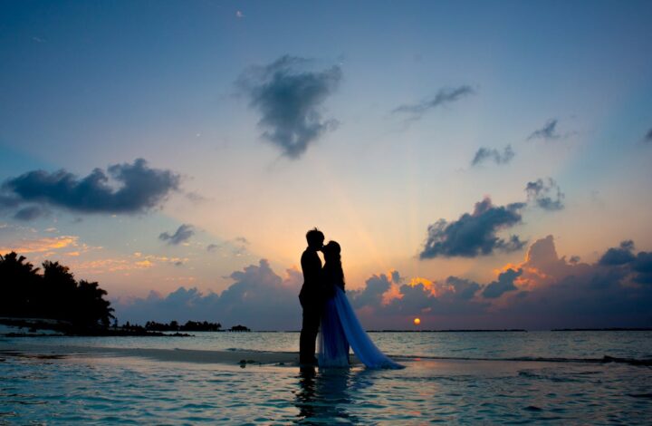 bride and groom stand on beach for blue hour wedding photography