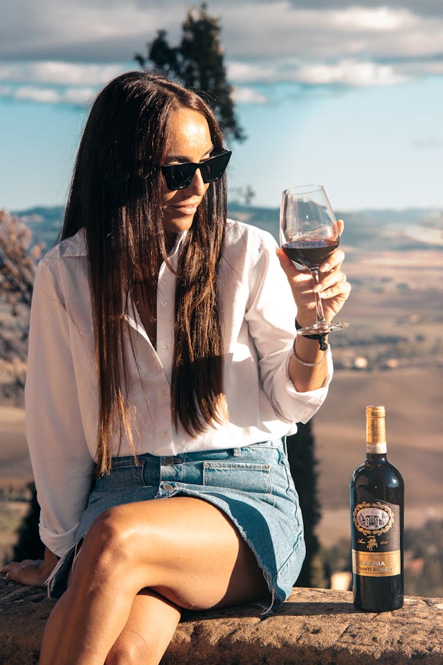 Young Brunette Drinking Red Wine Outdoors on solo bachelorette trip
