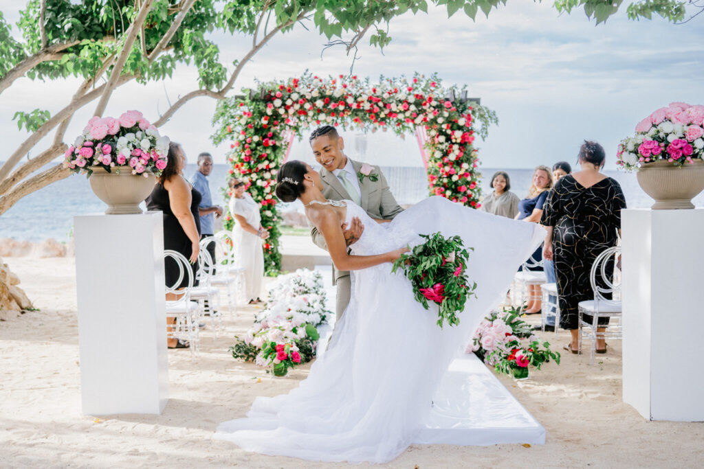 destination wedding in Jamaica bride and groom kiss on beach after ceremony