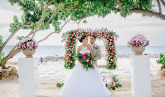 destination wedding in Jamaica on beach with pink and red flowers