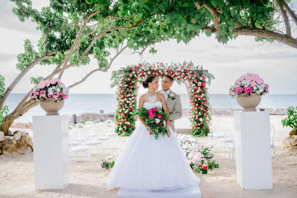 destination wedding in Jamaica on beach with pink and red flowers