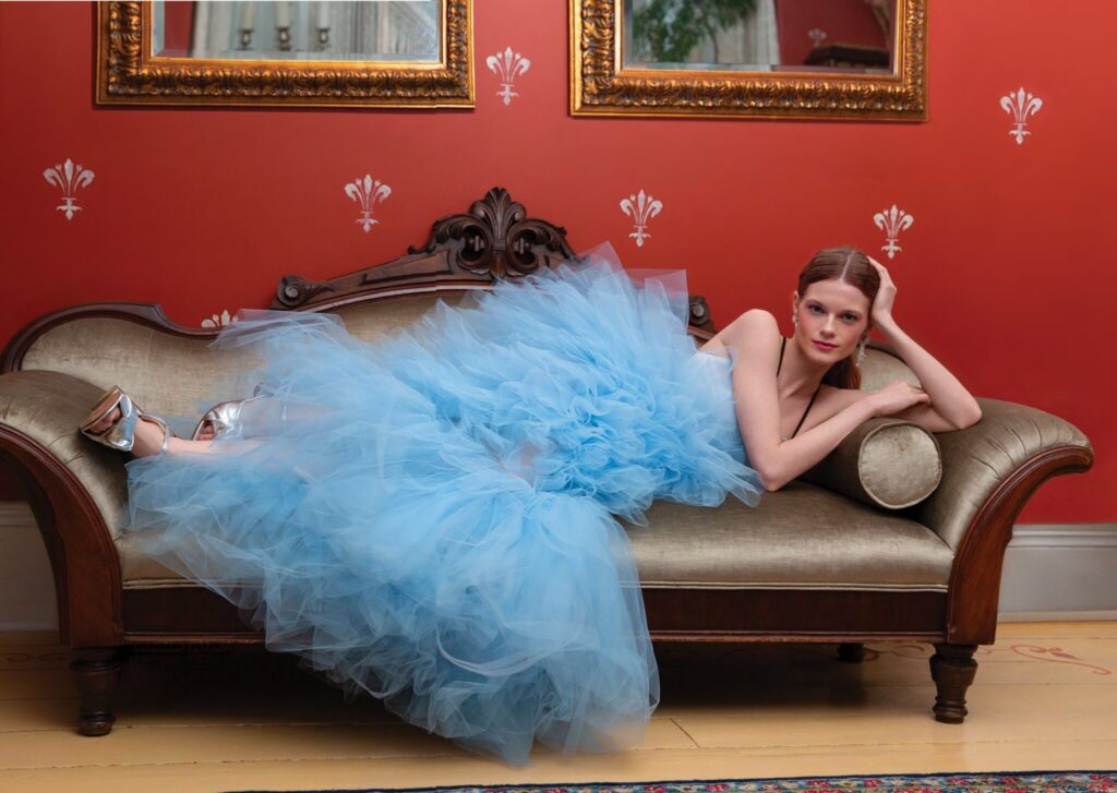 bride laying on vintage couch wearing something blue wedding dress with ruffles