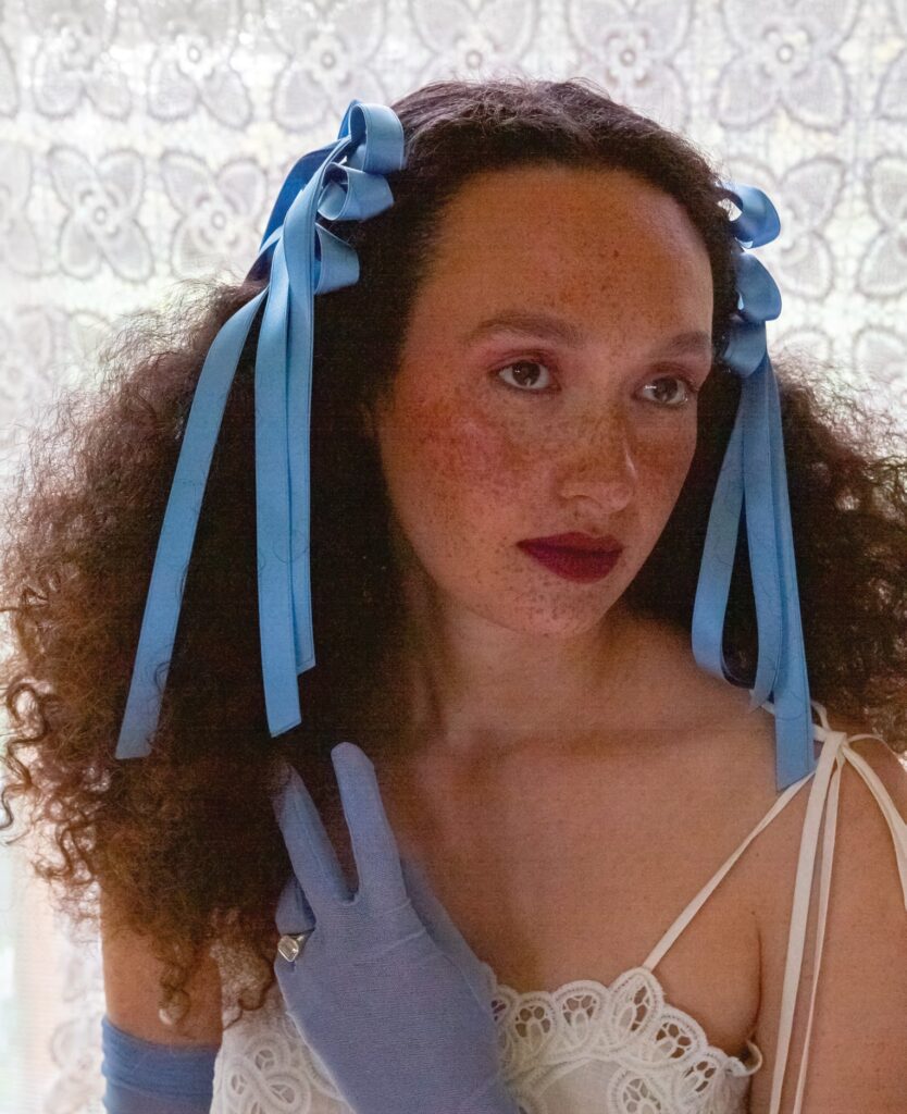 Bride with beauitufl freckles on face wearing something blue hair bows and gloves