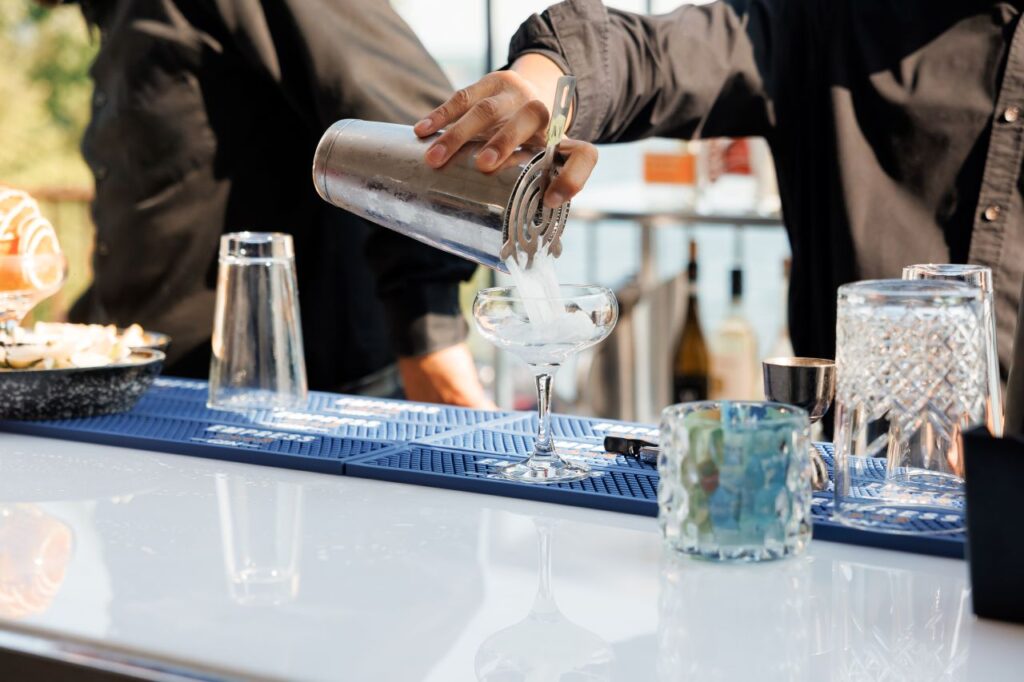 male bartender mixes cocktails at open bars at wedding - the best cocktail bar ever