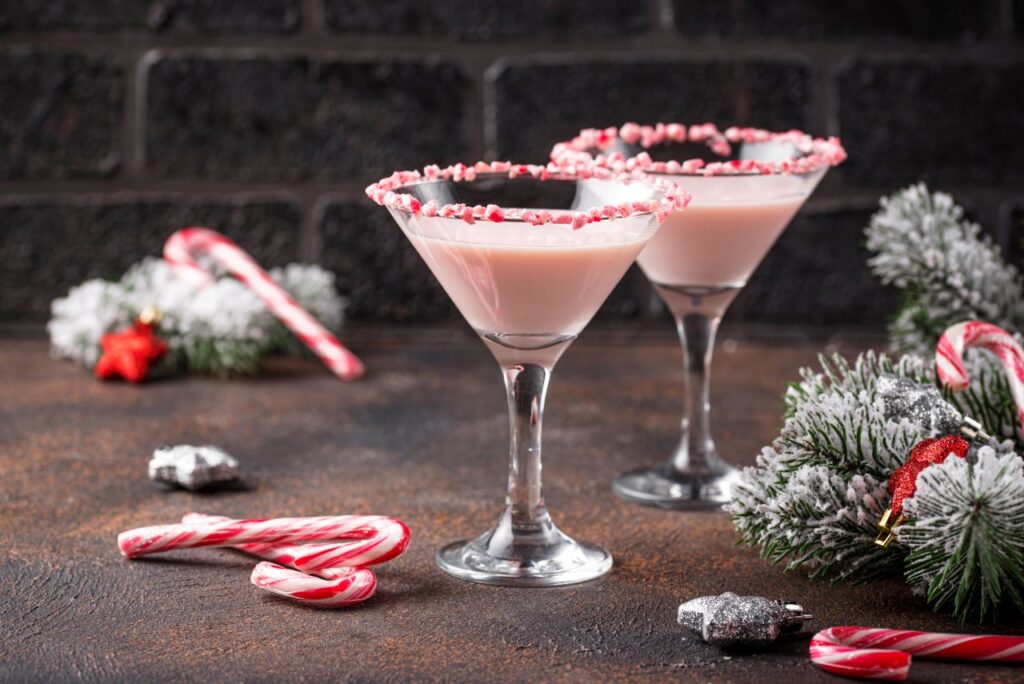 Pink peppermint martini with candy cane rim holiday cocktails - winter cocktail ideas