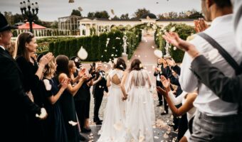 two brides tie the know on the courthouse steps after creating the perfect wedding guest list