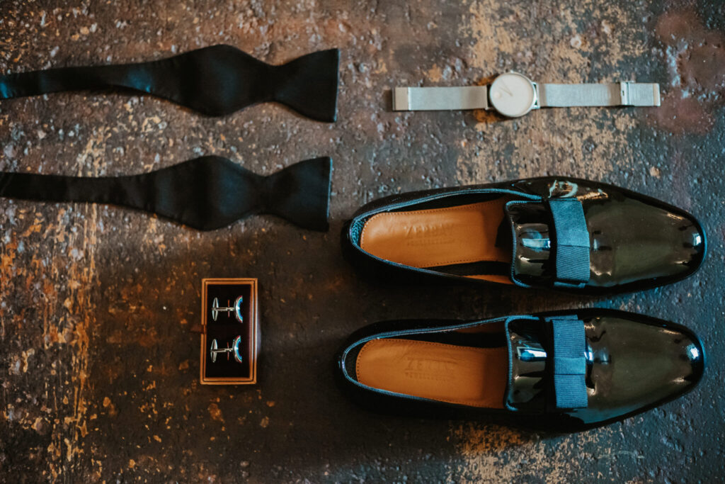 groom accessories flatlay black shoes bow tie watch cufflinks groom flatlay destination wedding
