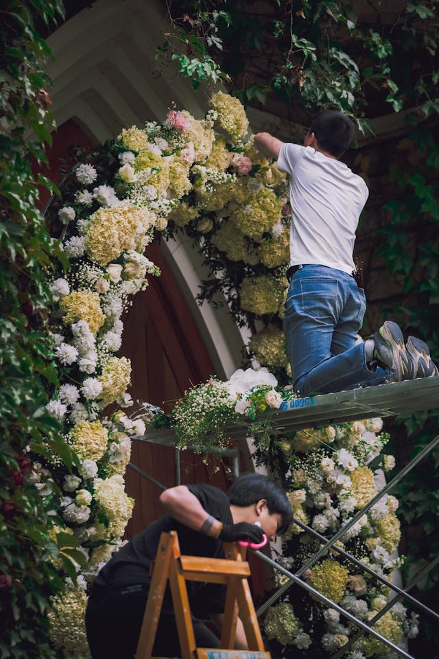 wedding florist working on large flower installation